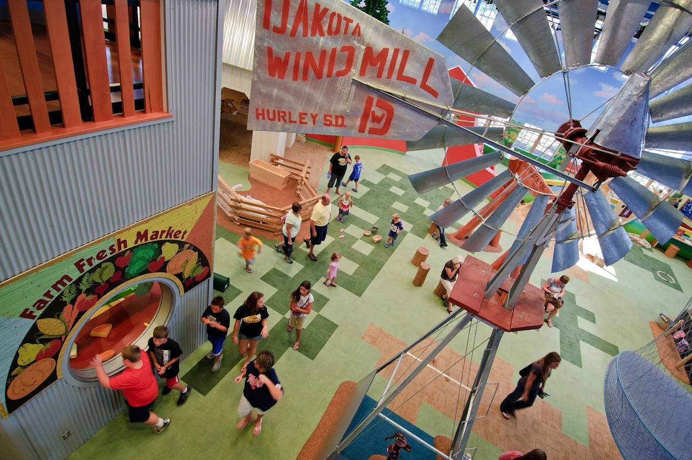 An aerial view of a play area in a museum made to look like a farm, complete with a windmill.