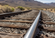 Close-up of railroad tracks running through a rocky Nevada desert landscape with mountains softly blurred in the distance.