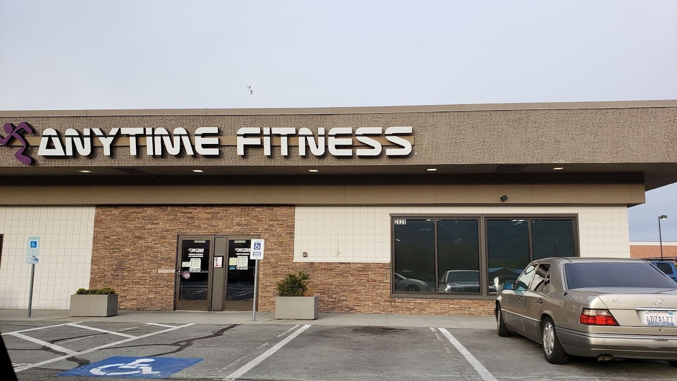 A brown and brick building with the white lettering "Anytime Fitness" above the door.