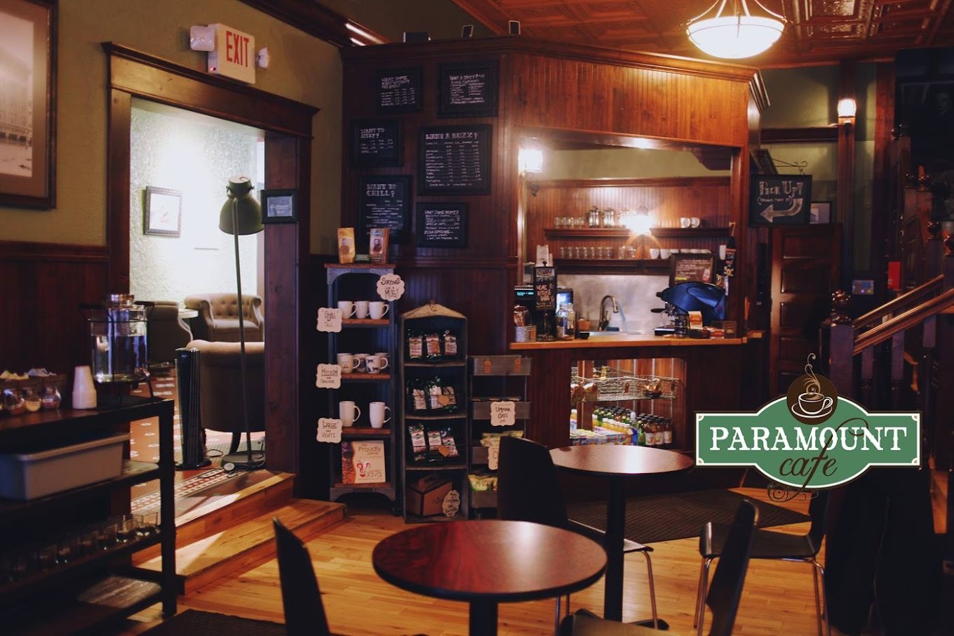 An indoor view of a cafe front counter and seating area, a ornate room made from wood giving the room a very classical feel.
