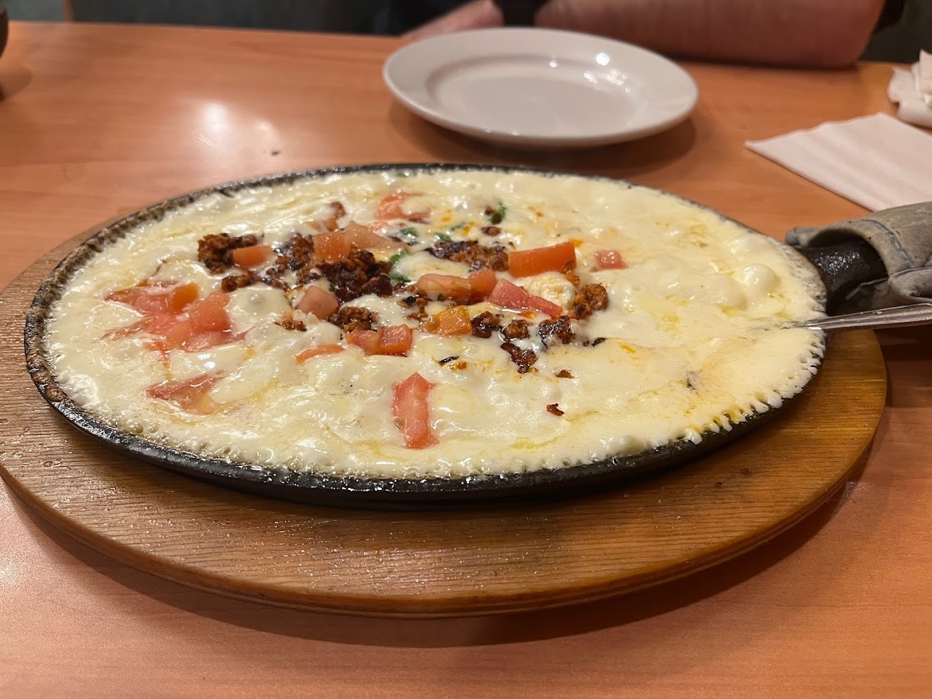 A view of a pan with cheese and veggies topped in the middle.