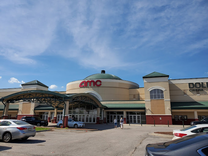 An outside view of a movie theatre building, a large brown building with many different sections.