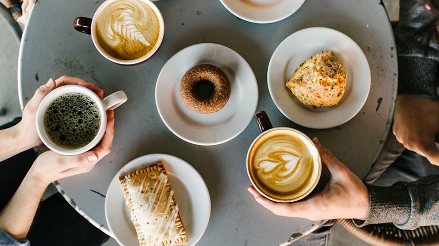 A serving tray consisting of many different kinds of coffee, and baked pastries such as a scone and pastry.