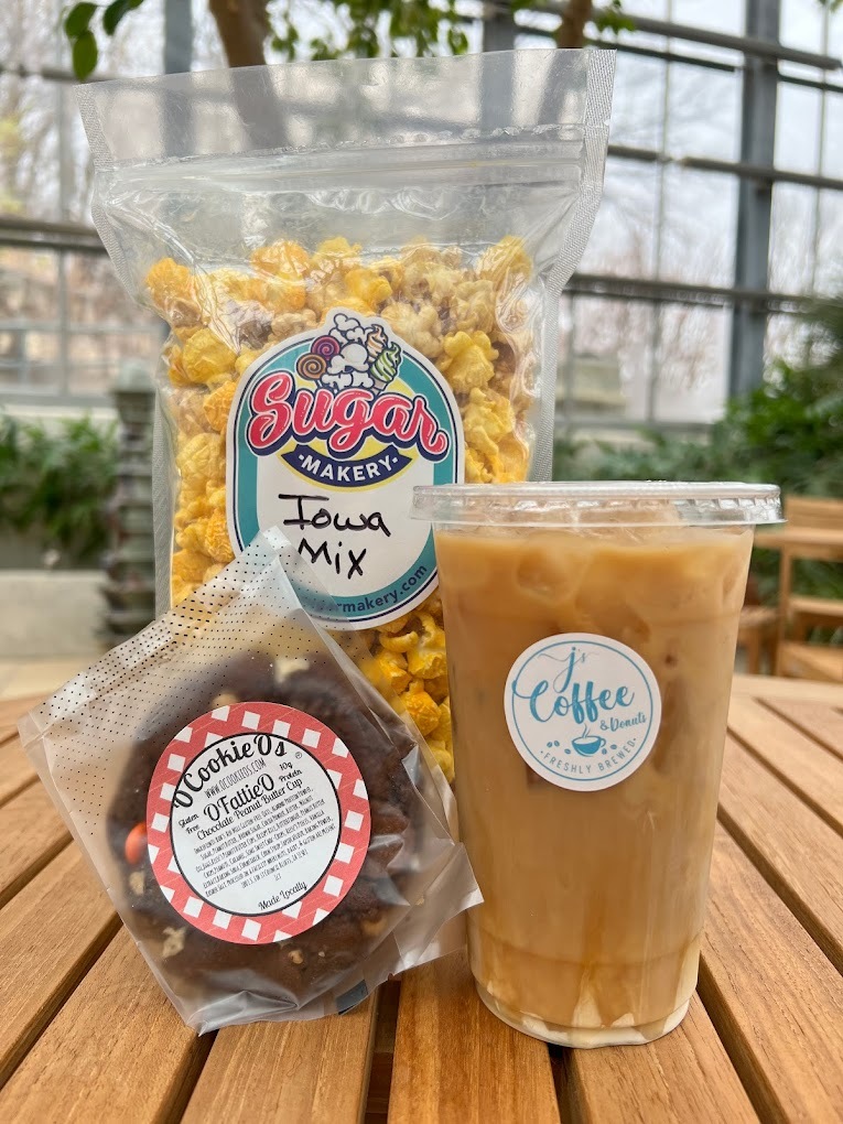 A view of an iced coffee paired with a bag of popcorn and a cookie.