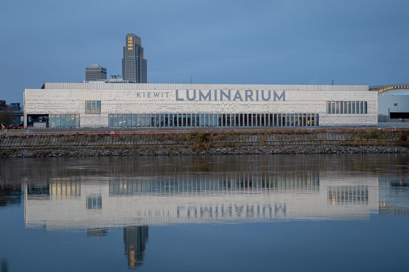 An outside view of a large white museum building, lined with large windows.