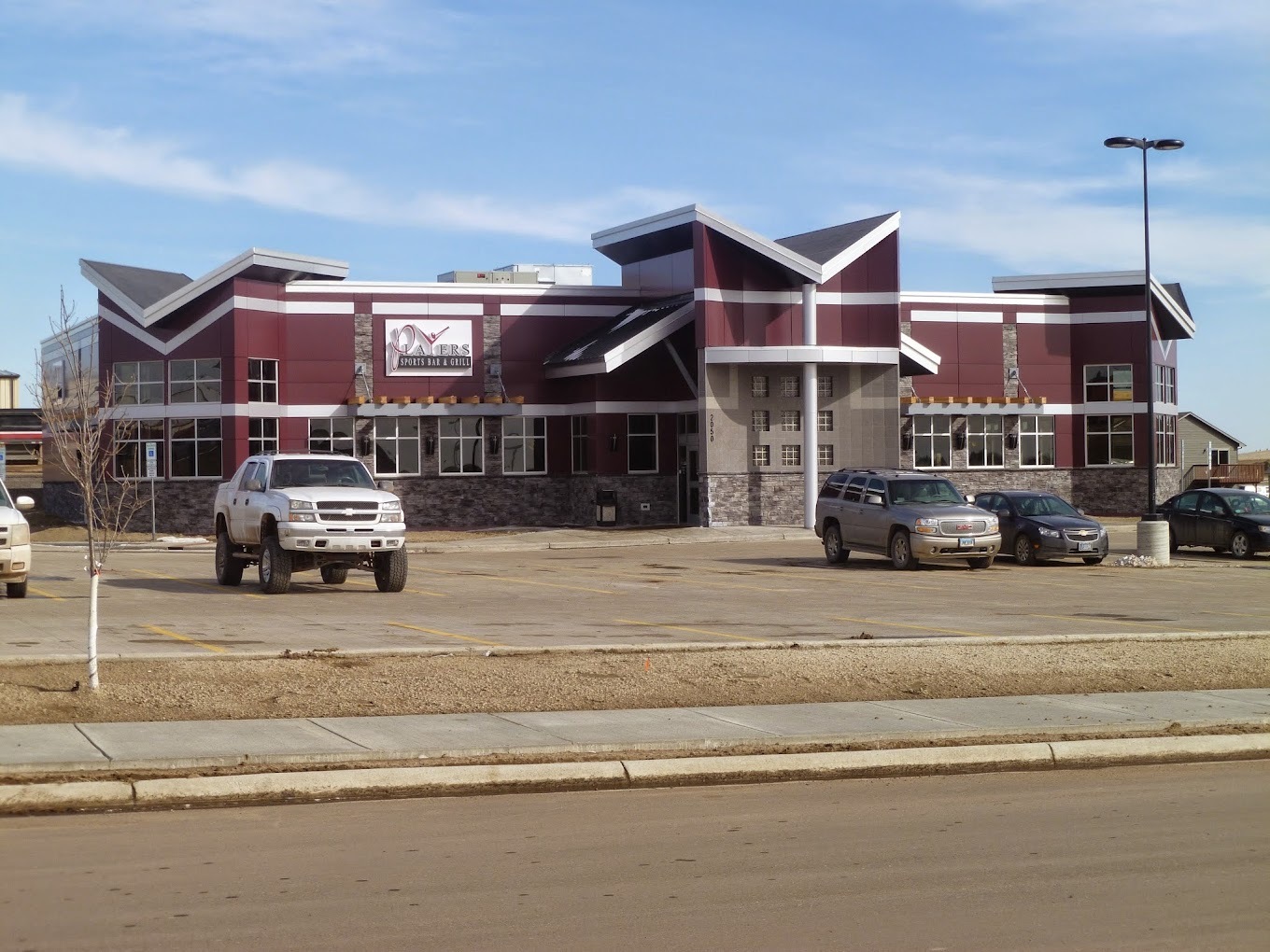 An outside view of a restaurant with red siding and white trim as accenting.