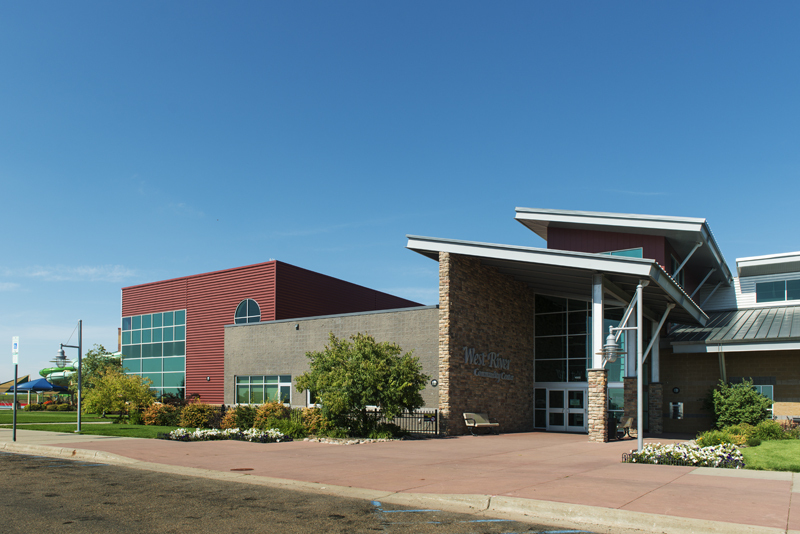A large modern style building with red and cement base and brick accenting.