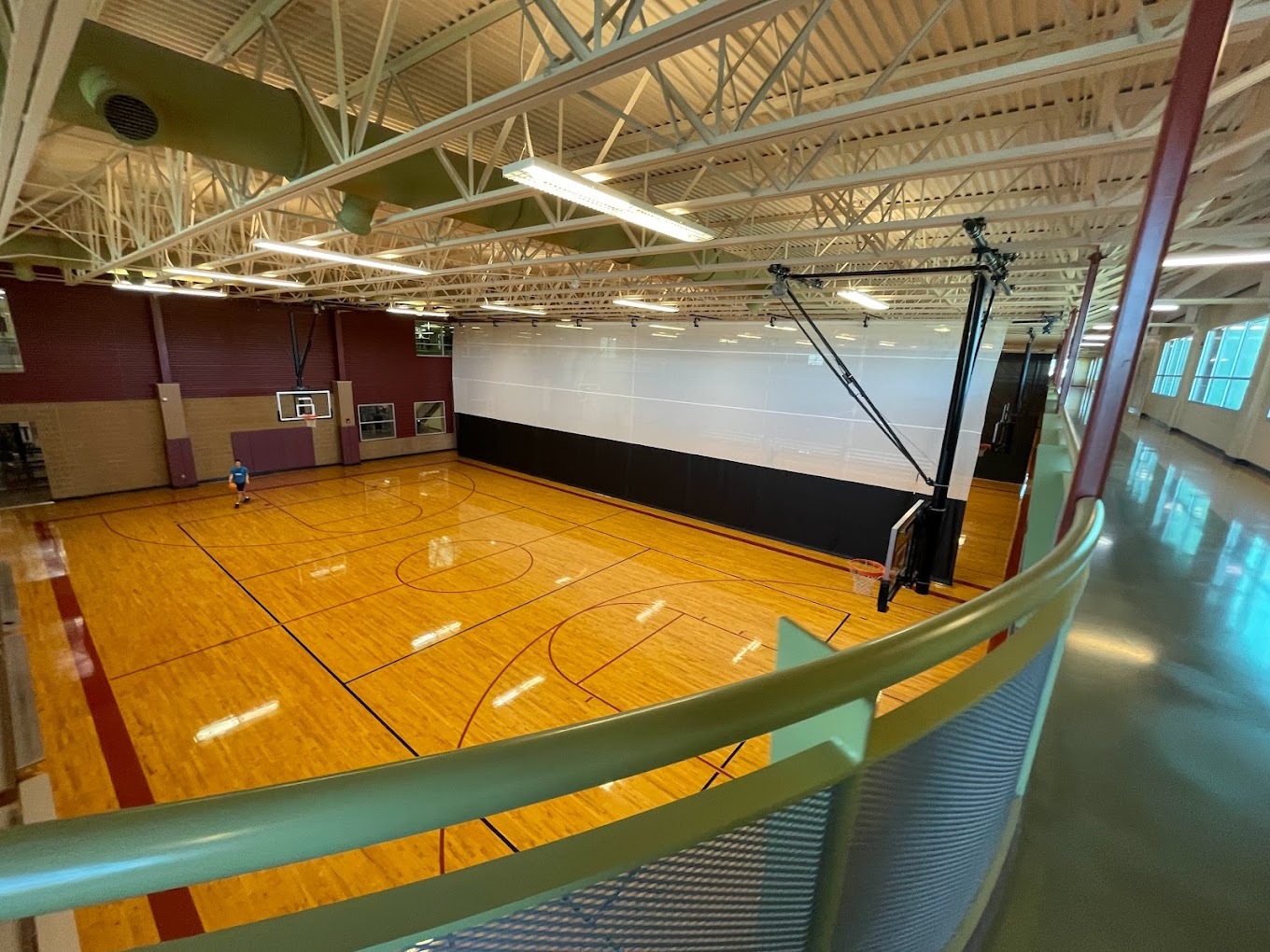 A large gym, with a balcony above the basketball hoops.