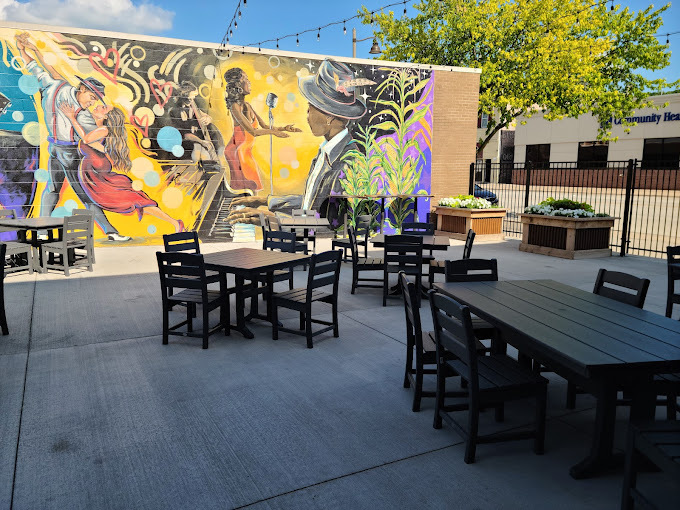 Smooth wooden outdoor seating area with graffiti/mural art on the back wall.