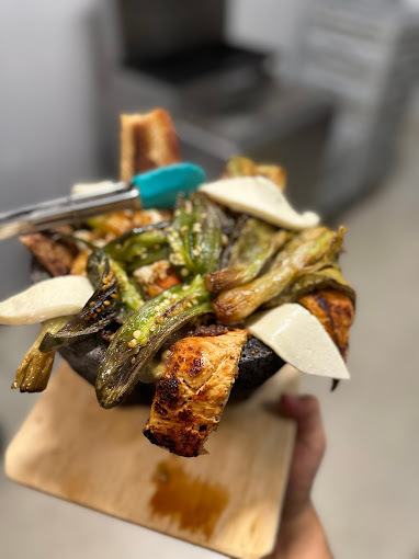 Close view of a green dish on top of a wooden board.
