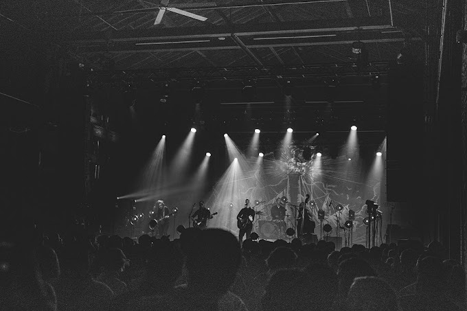 Black and white image of a stage with a full concert.