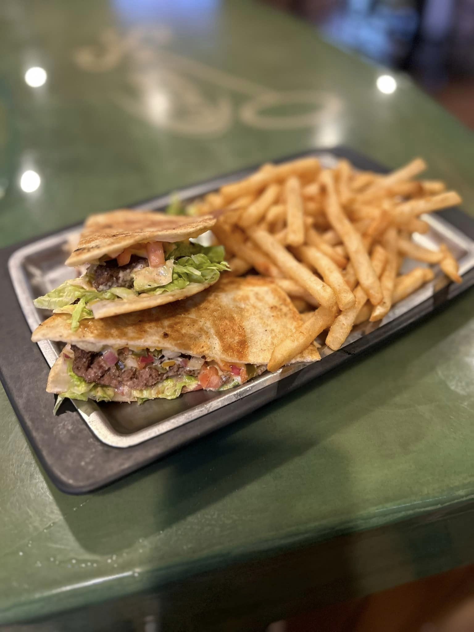 Taco sandwiches and fries in a rectangular plate.