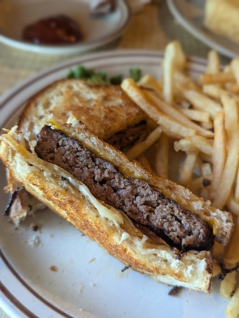 A white plate with a panini pressed sandwich along with a side of fries.