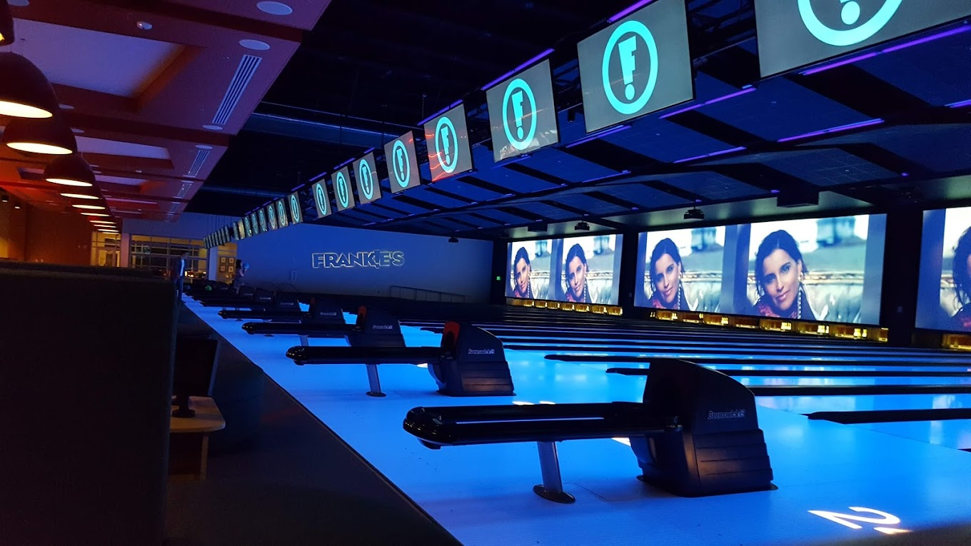 An view of bowling alley lanes with lots of colorful lights.
