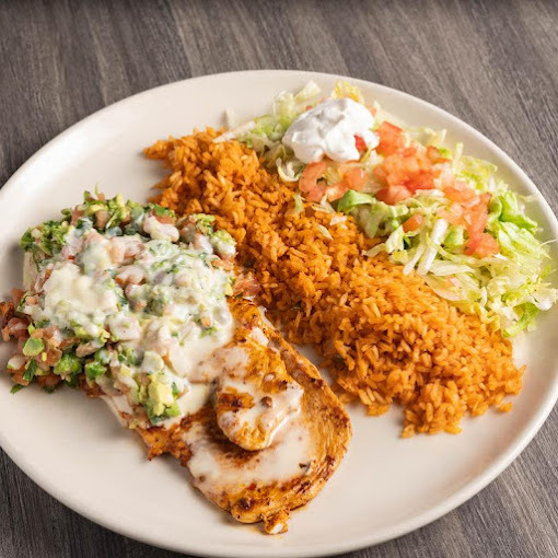 A view of a white plate full of food from rice, salad, and an open faced sandwich with shrimp cheese and garnishes.