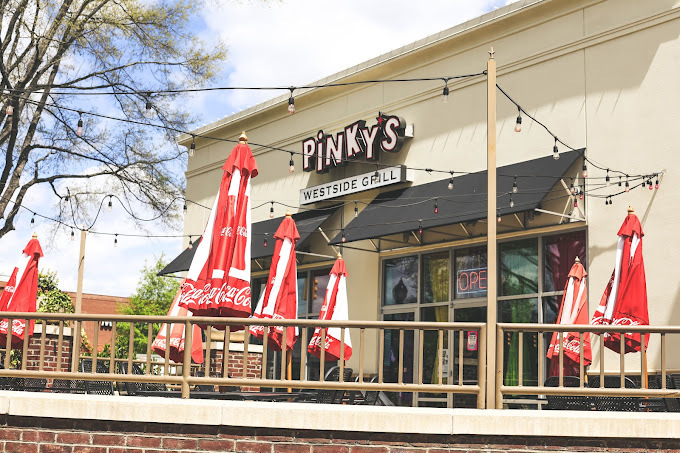 An outside view of a restaurant with many string lights over hanging above the outdoor seating area.