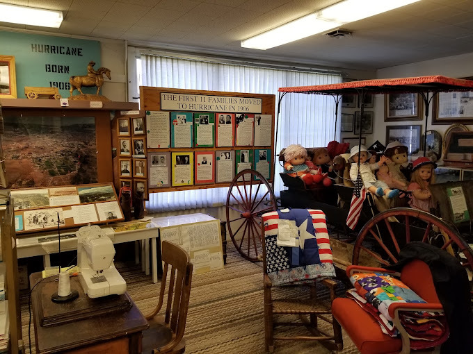 A view of a room filled with lots of American frontier memorabilia; such as flags, model horse and buggy, and pioneer dolls.
