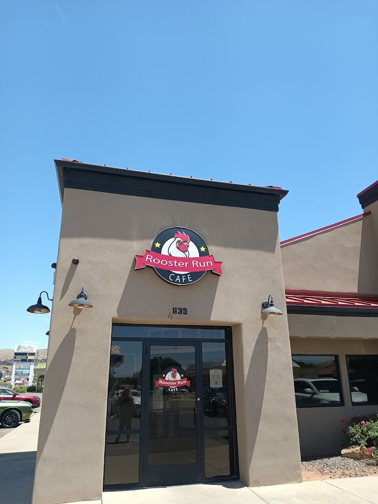 A beige building with a red and white sign above the glass door entrance.