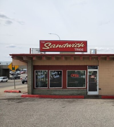 Outside view of a brown building with a red sign on the top.