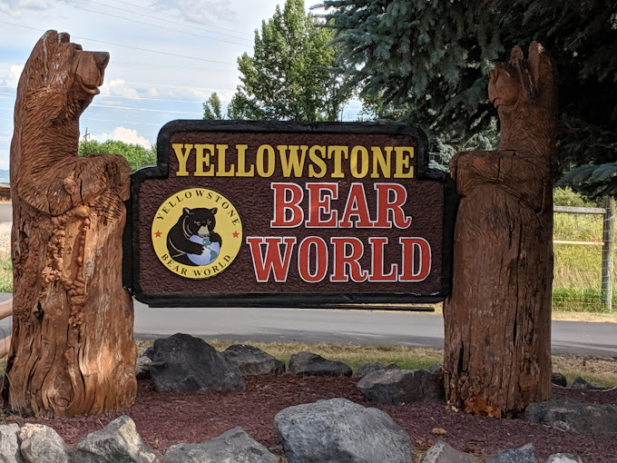Entrance sign that states "Yellowstone Bear World." The sign is held up by two wooden carved bears.
