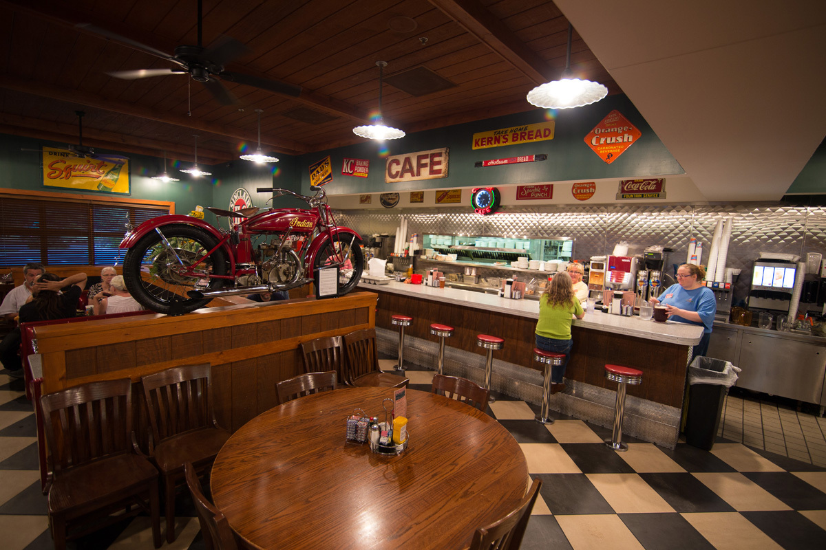 A cozy classic styled diner with turquoise walls and checkered floors.