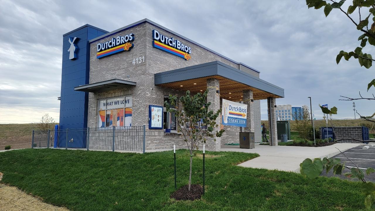 A grey brick and blue accenting on the building, with a stone awning over the door.