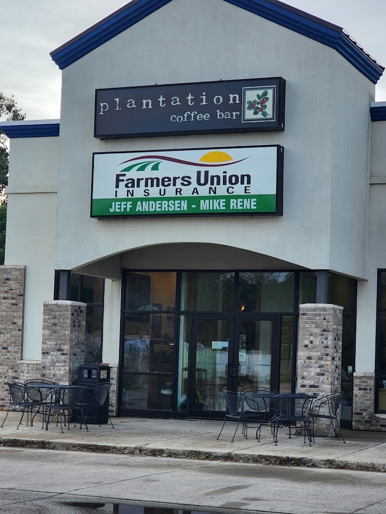 An outside view of an entrance to a commercial building, two signs are above the door.
