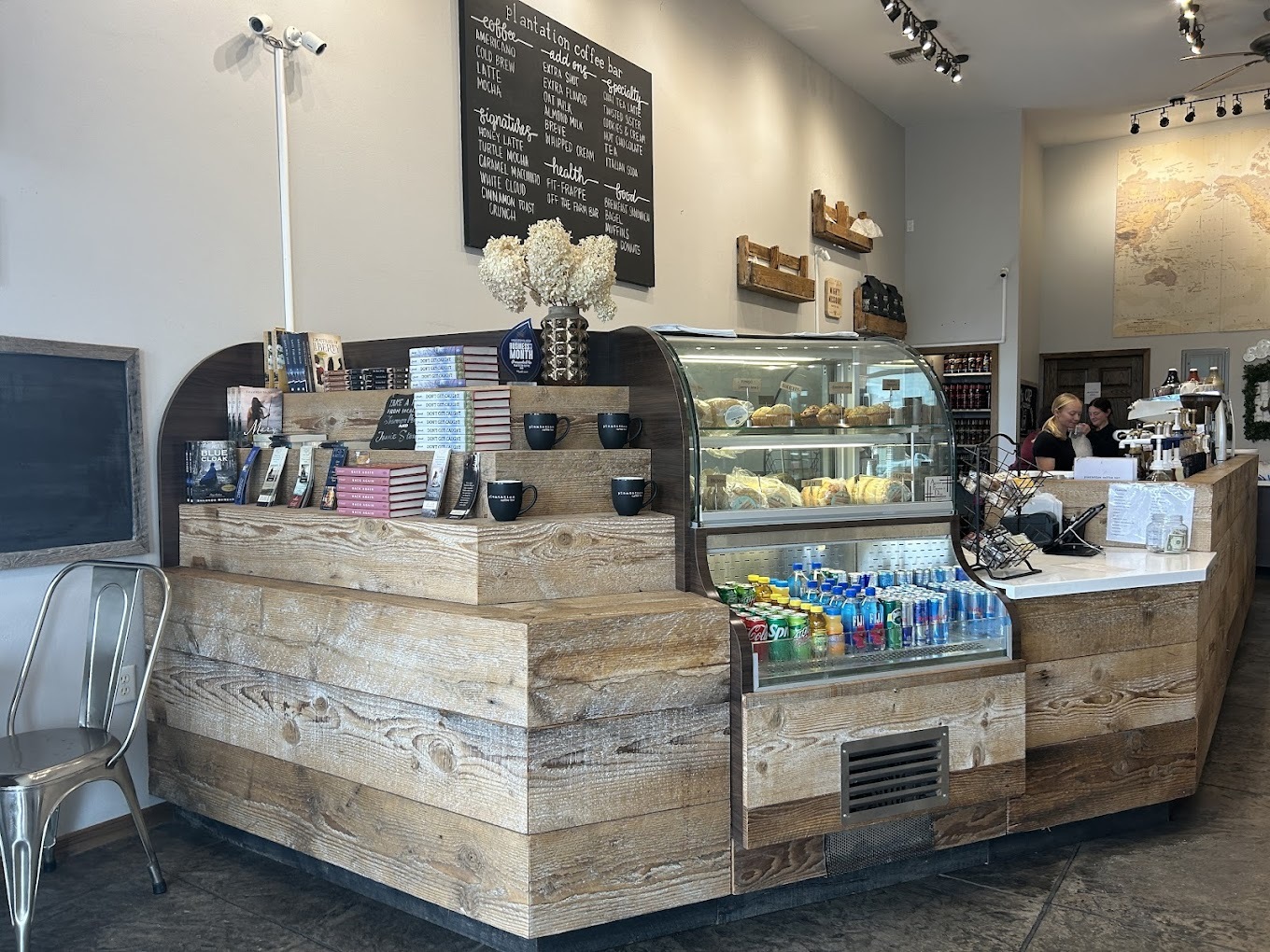 A view of a coffeehouse counter with a display case filled with treats