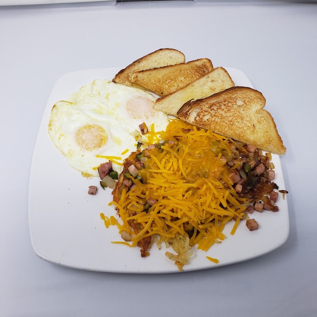 A white plate with hash browns, toast, and eggs, the hash browns are topped with onion, and peppers.