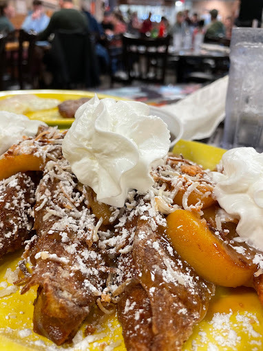 Dessert-like food with whipped cream on a yellow plate.