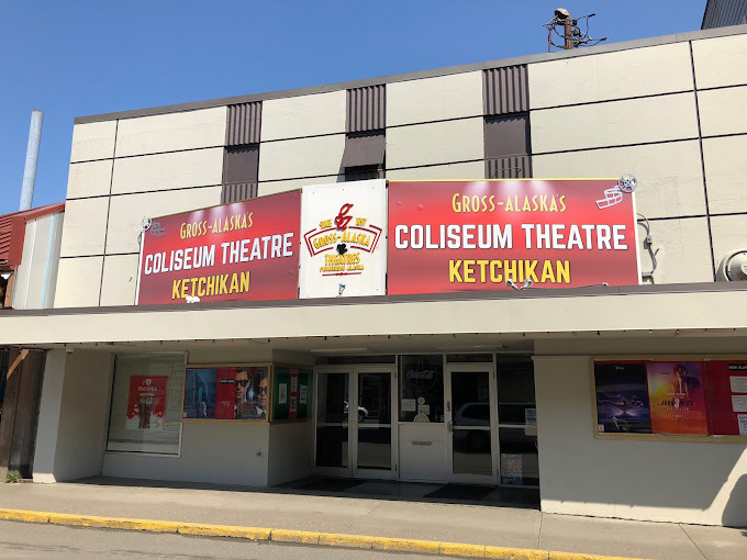 Outside view of a beige building. Large sign above the doors is red and states "Coliseum Theatre Ketchikan."