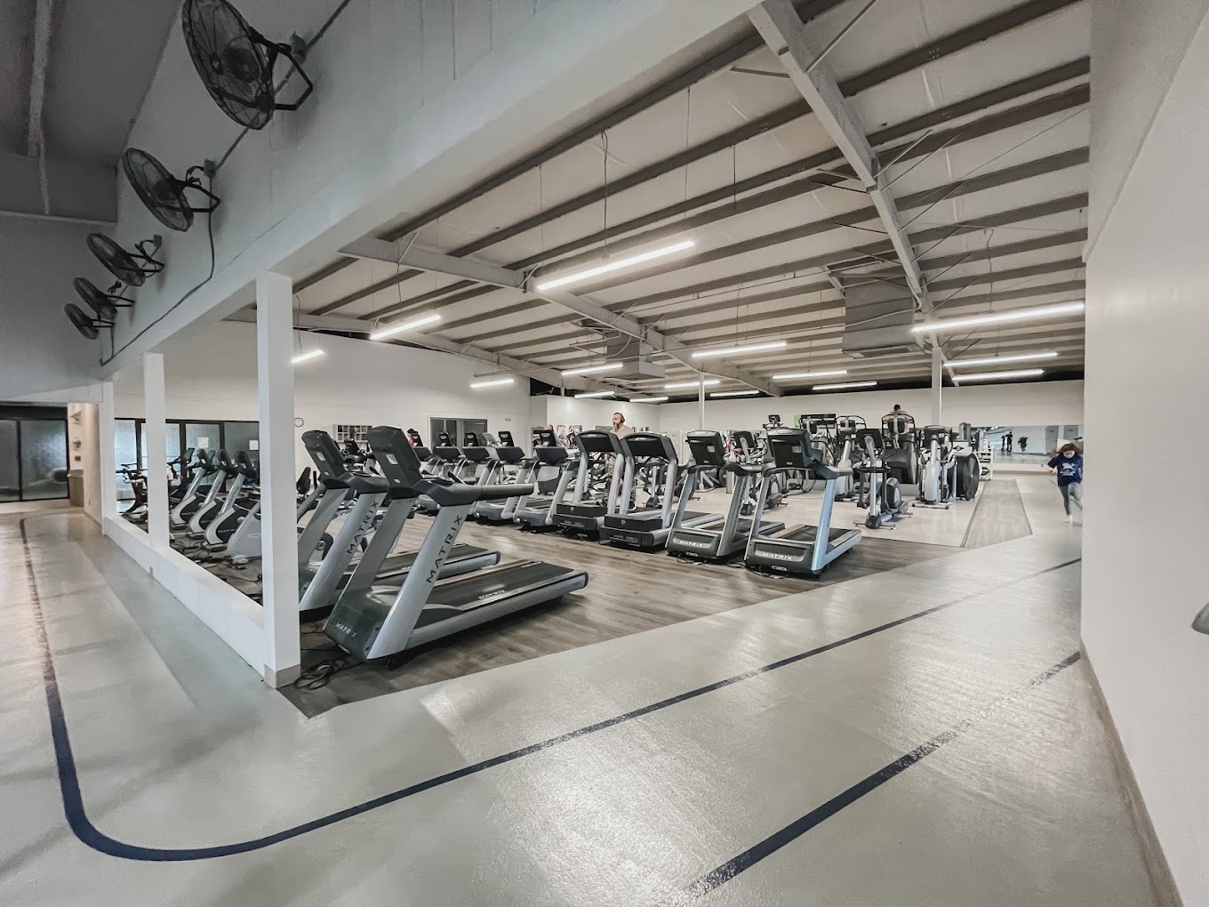 An view of a line of treadmills and a track surrounding the workout equipment.