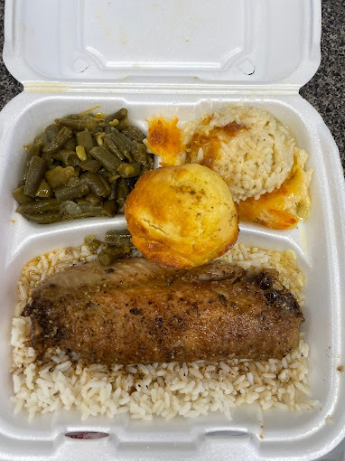 Rice, chicken, green beans, and a muffin in a white Styrofoam takeout container.