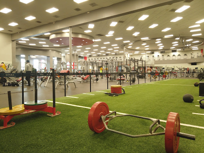 Interior view of a fitness center, featuring a green area that has weights set on it.