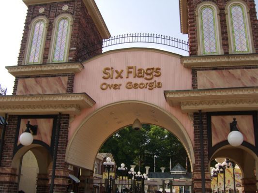 Six Flags Over Georgia entrance with a pink arch and tower columns on either side of the arch.