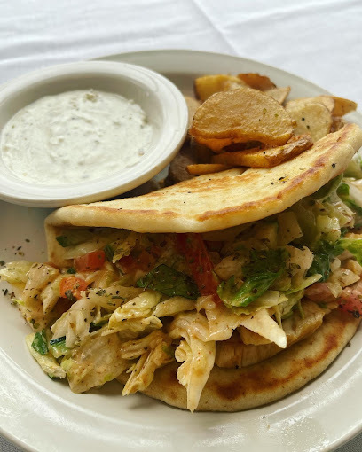 Taco-like dish with meat, potatoes, and a side of sauce, all on a white plate.