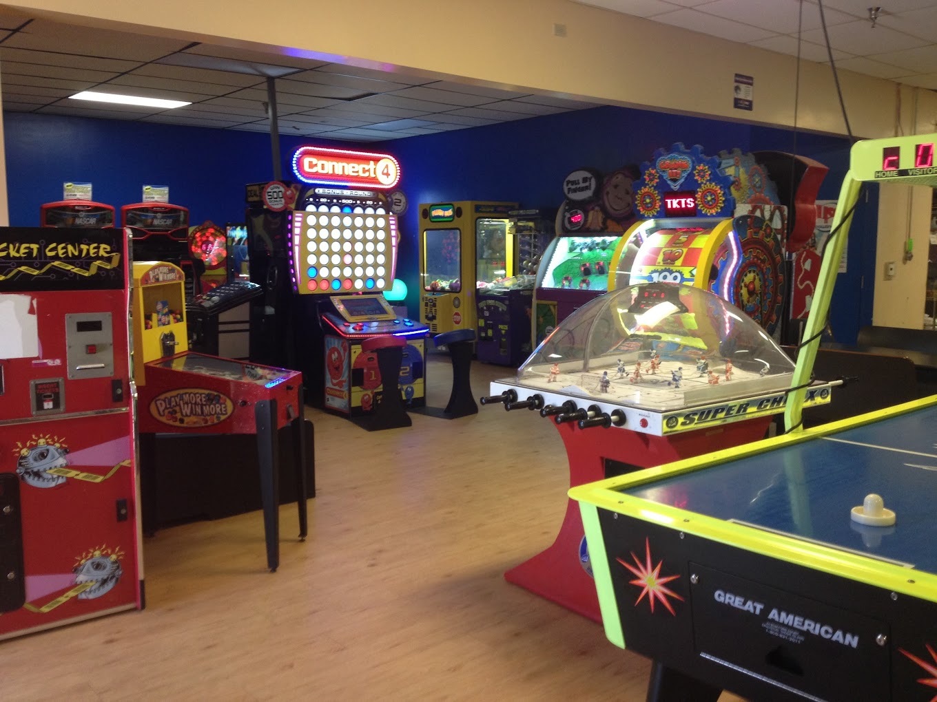 A view of a dimly lit room with arcade games lit up.