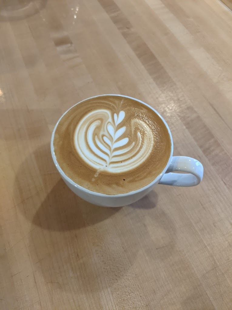 A view of a white coffee cup with an spiral latte art.