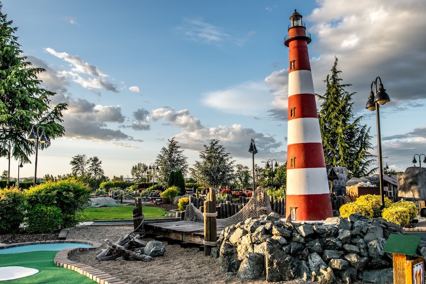 Landscape photo of mini golf park, depicting an landscape installation of a coastal themed scene with a lighthouse