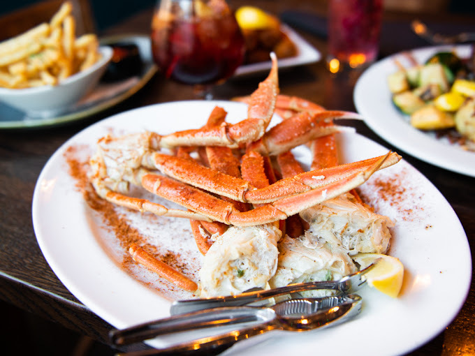 Crab on a white plate. Numerous other dishes are viewable in the background.