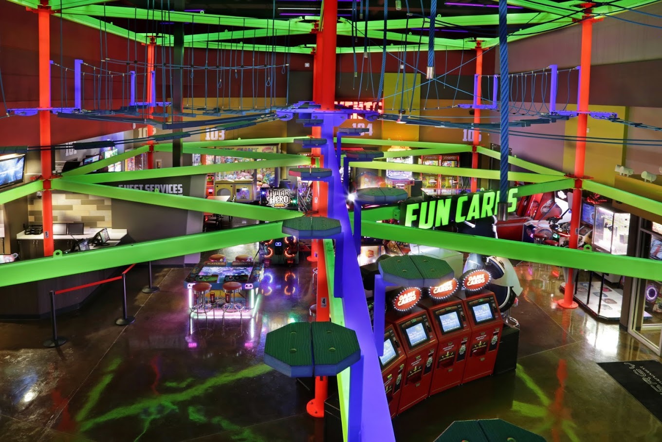 An above ground view of a colorful, glowing, arcade room filled with all kinds of arcade games.