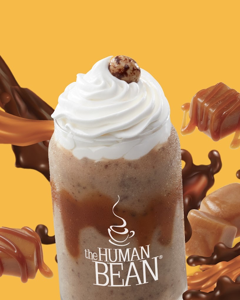 A view of a caramel and chocolate blended drink topped with whipped cream and a candy garnish.