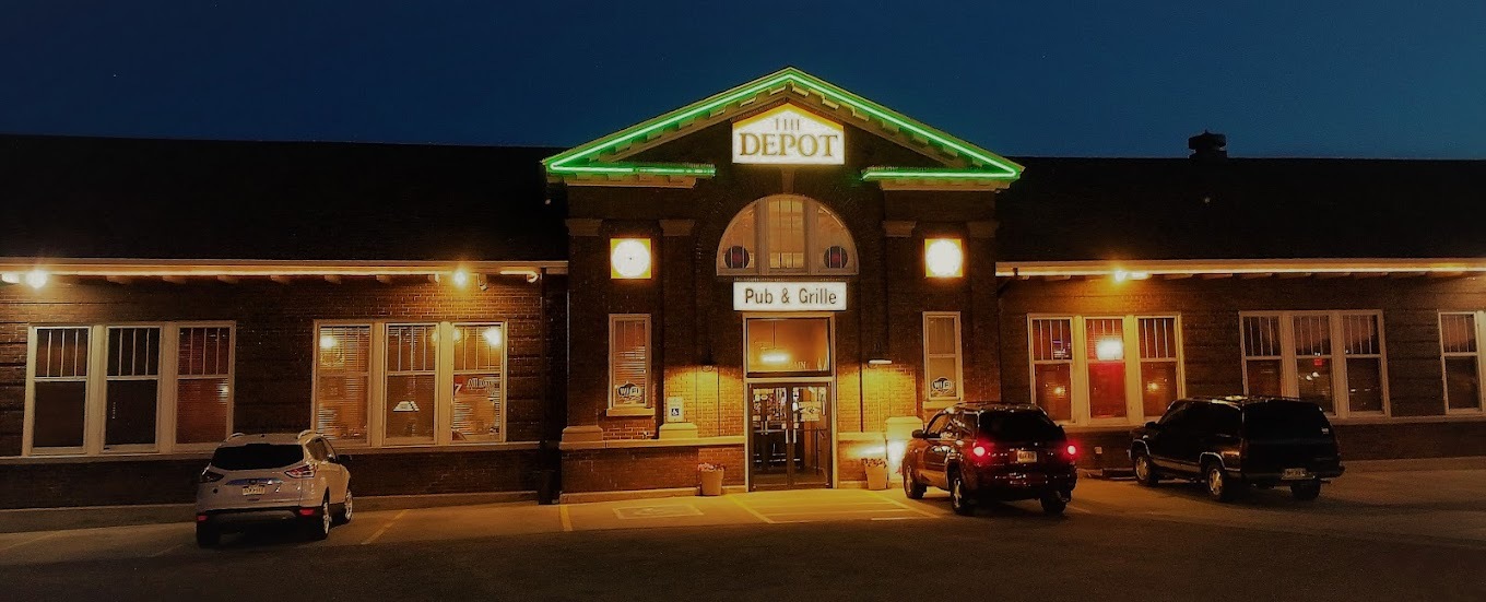 A brown building with green lighting on the roof.