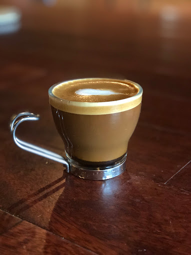 Glass coffee mug filled with an espresso coffee shot.