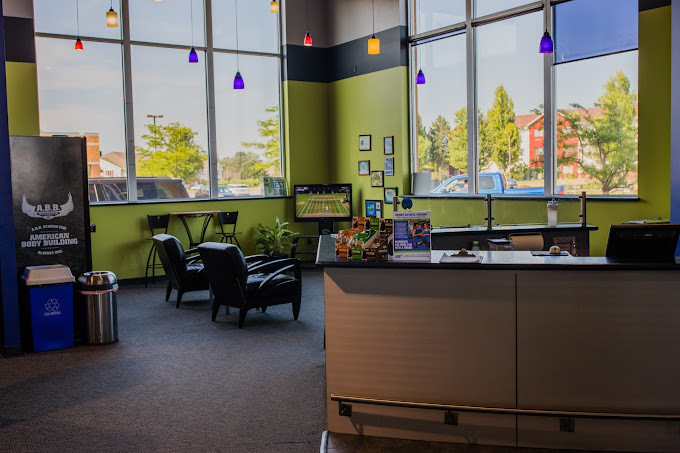 An indoor view of a room of green walls and large windows, a desk and a seating area are consistent of the room.