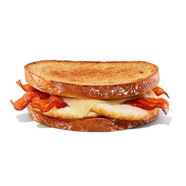 A view of a grilled breakfast sandwich, with egg, cheese, and bacon.