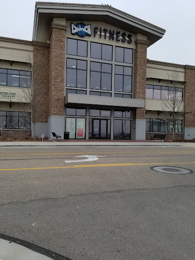 Brown building with brick accents and large glass windows. Signage close to the roof reads "Crunch Fitness."