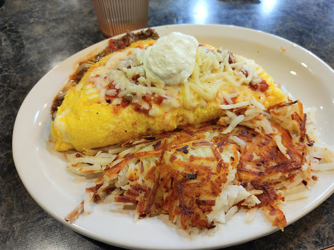 Hashbrowns and eggs on a white plate.