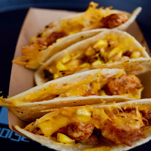 Close view of four cheesy tacos.