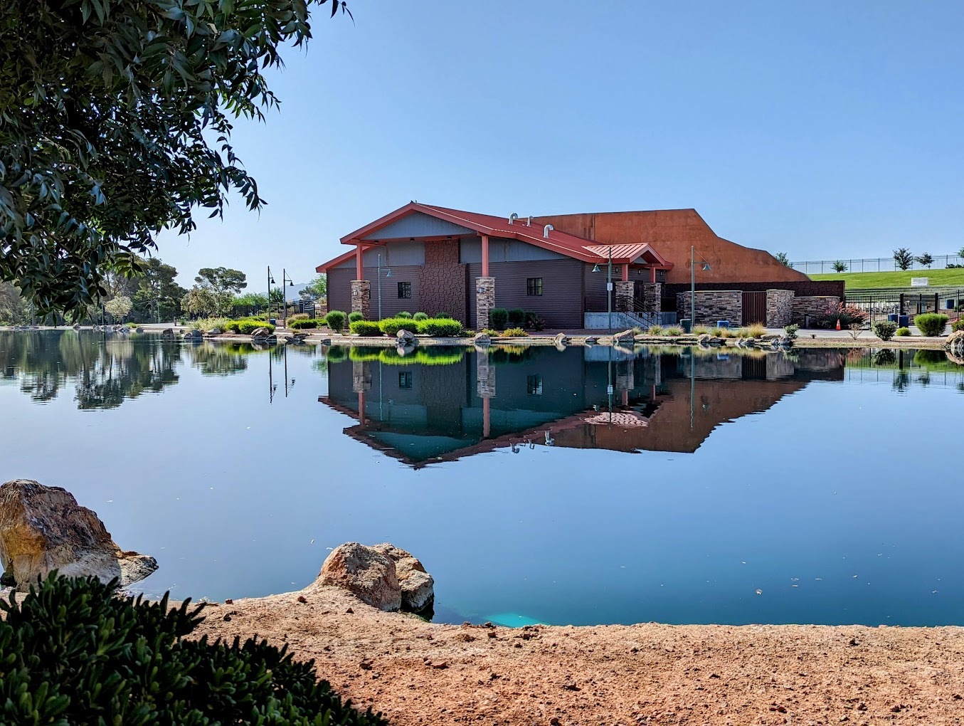 A landscape view of a park building surrounded by a small pond.